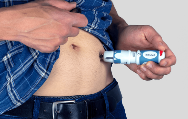 Hombre inyectándose insulina con el inyector Insujet en su abdomen
